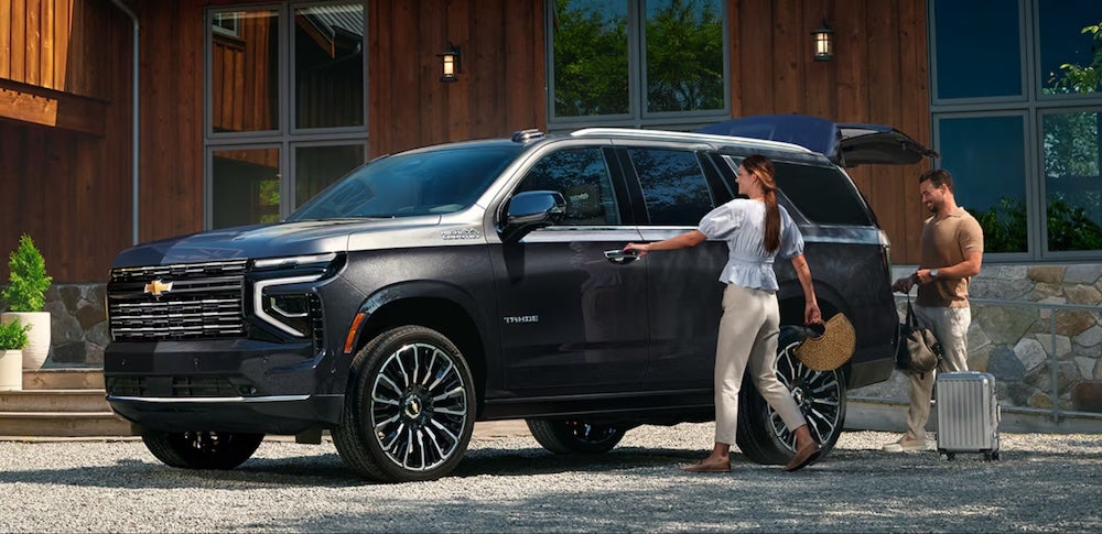 Two people getting into a gray 2026 Chevrolet Tahoe SUV