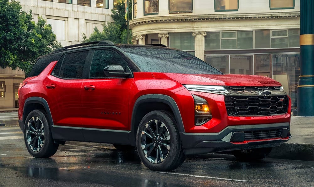 A red 2026 Chevrolet Equinox SUV on a rainy city street