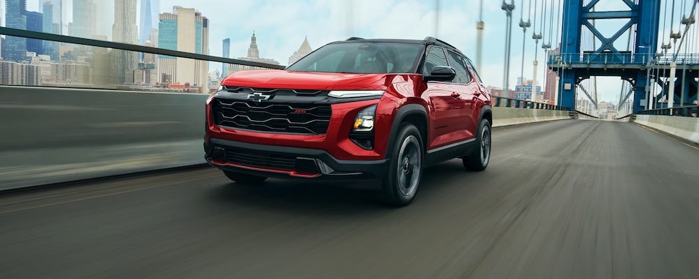 A red 2027 Chevrolet Equinox SUV driving over a bridge
